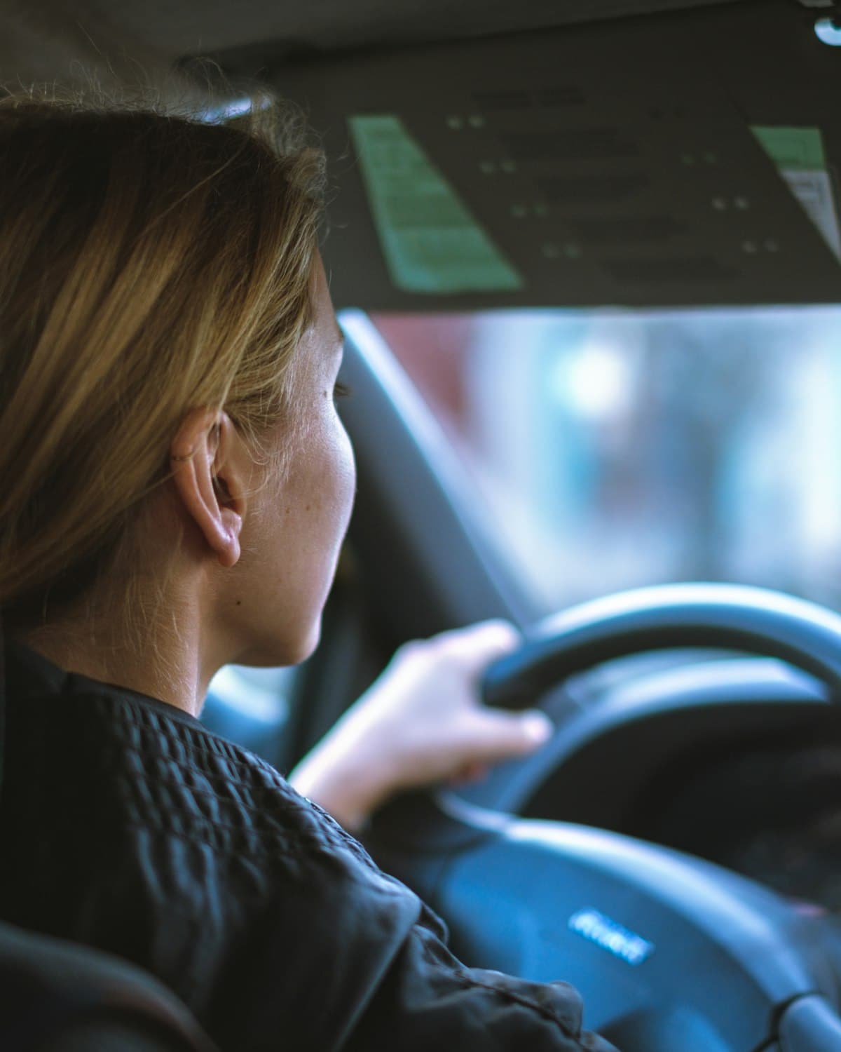 Cursist achter het stuur van een lesauto met beide handen op het stuurwiel